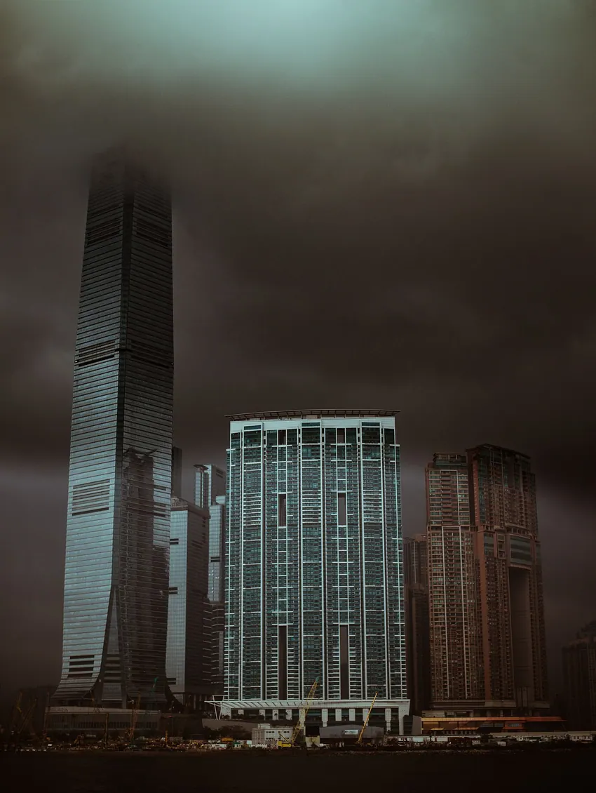 Dark towers on the Hong Kong waterfront beneath low cloud