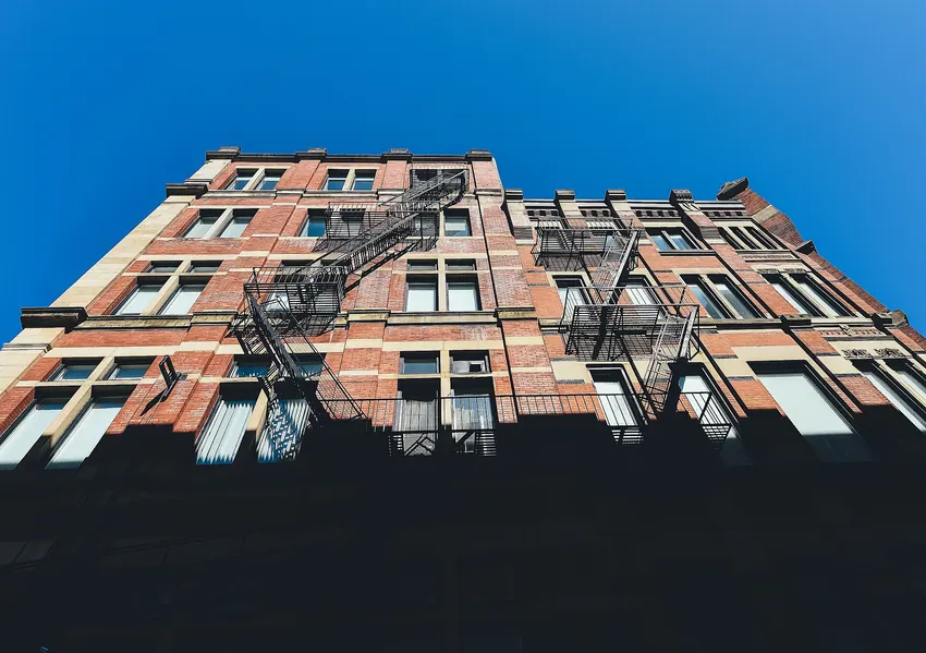 Brick apartment facade against a clear blue sky