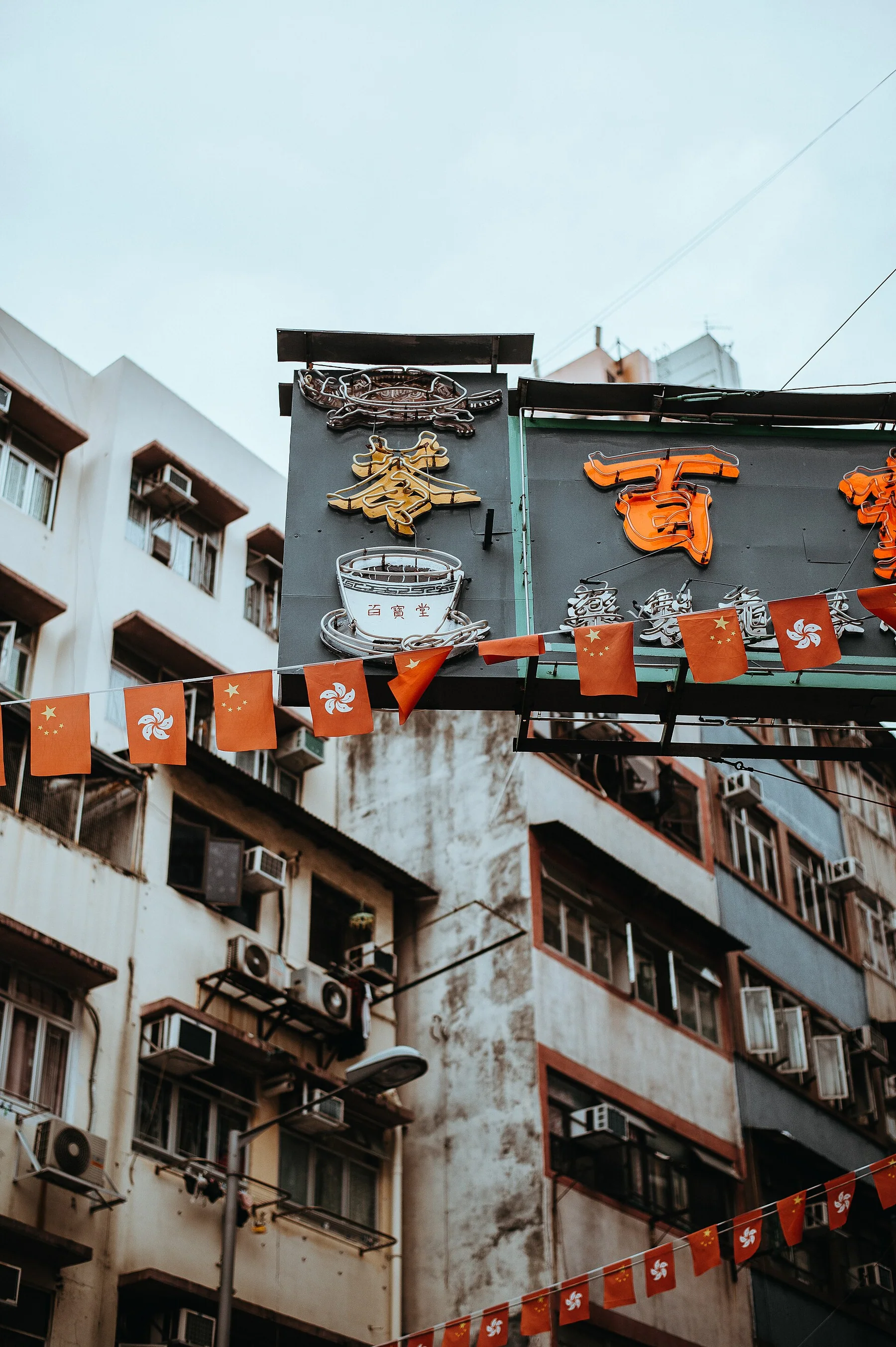 Narrow city street with suspended signs and balconies