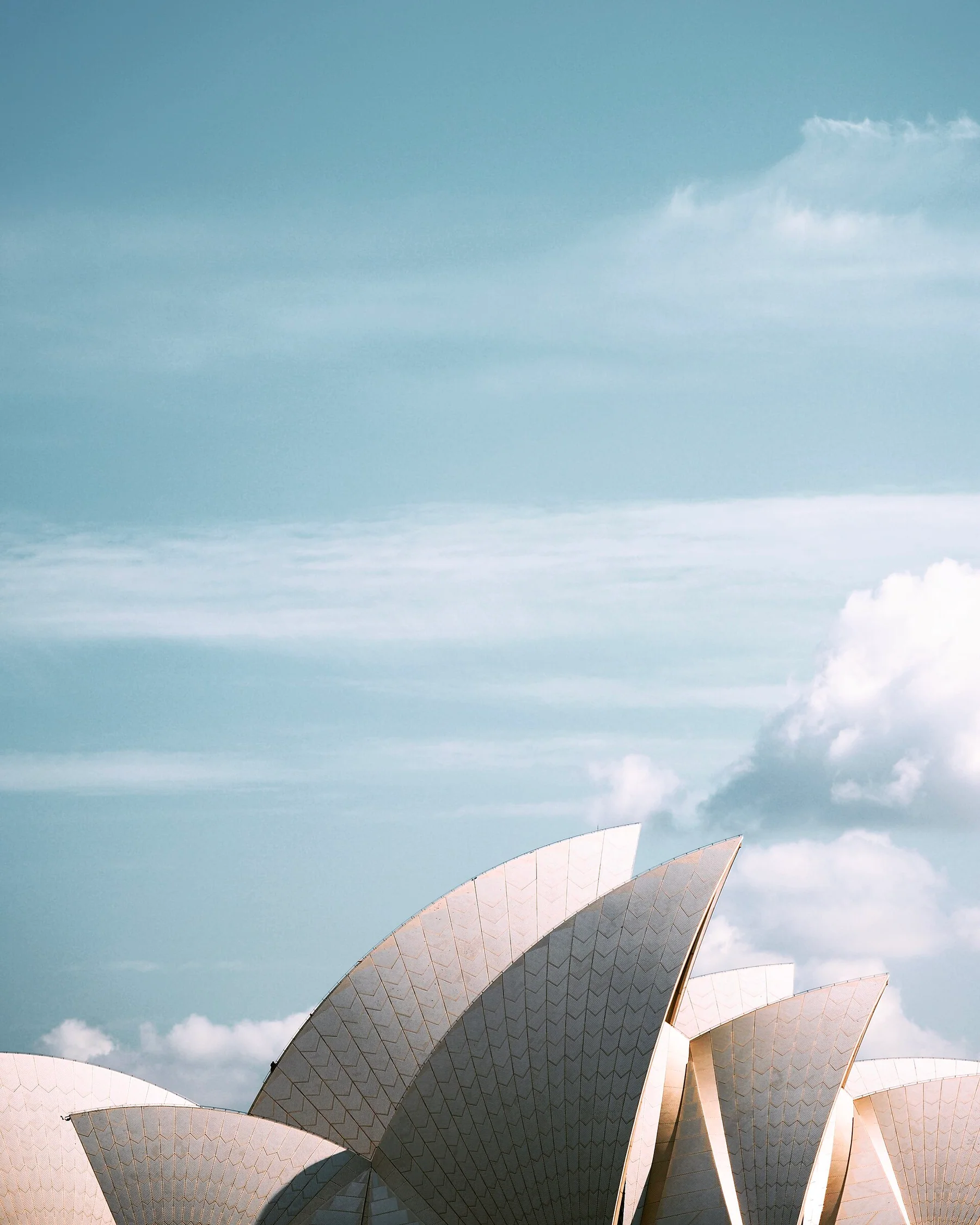 Sydney Opera House rooflines beneath a pale sky
