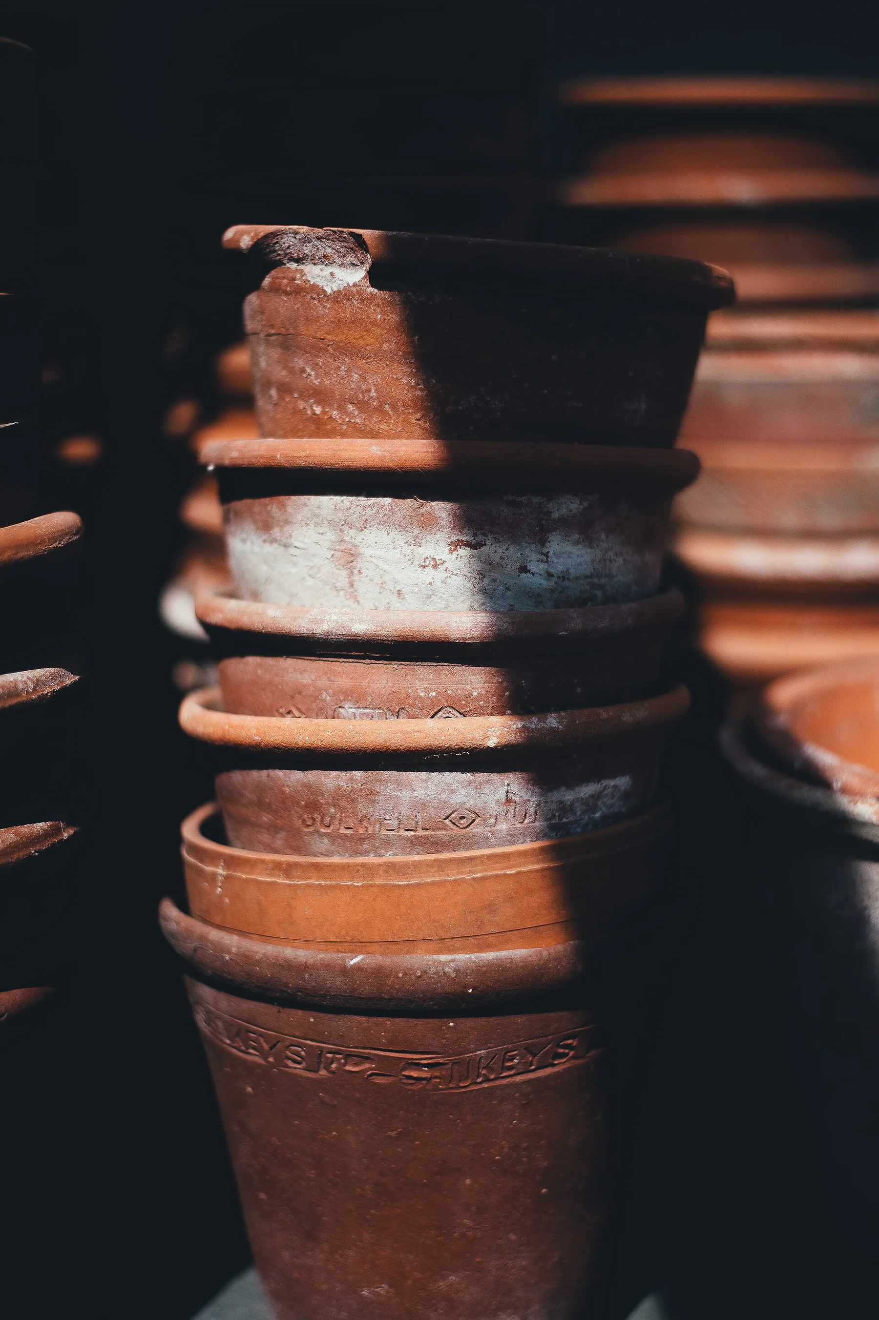 Stack of warm earthenware pots in soft interior light